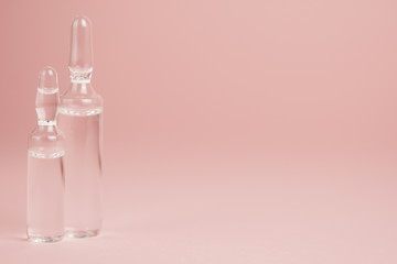 Glass medical ampoules on a pink background close-up, copy space,selective focus,macro photo.