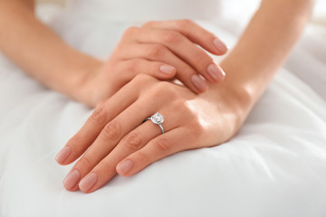 Fototapeta na wymiar Young bride wearing beautiful engagement ring, closeup