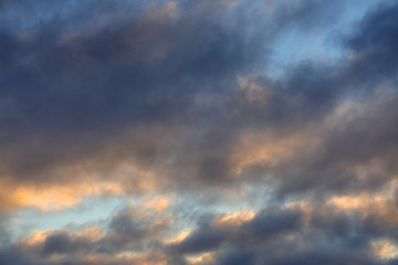 Naklejka na ściany i meble Sky background with dense clouds lit by the sun.