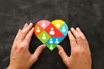 image of heart shape tangram puzzle blocks with people icons over wooden table ,human resources and...
