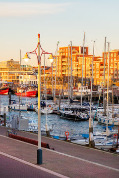 Evening view of Scheveningen harbour with boats, apartment buildings, bars and restaurants in The Hague