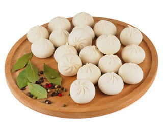 frozen Khinkali on a wooden board with spices
