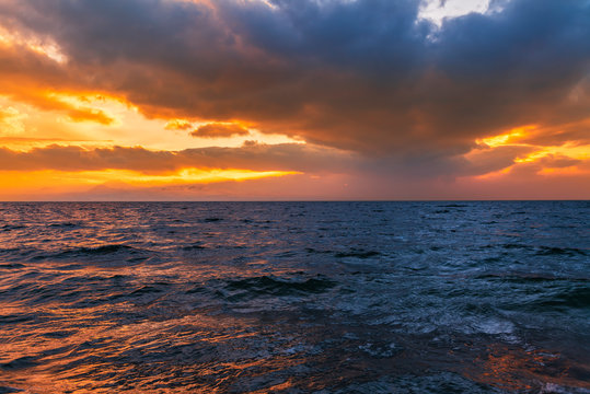 Beautiful landscape. Bright colorful sunset with dramatics clouds over the lake. 