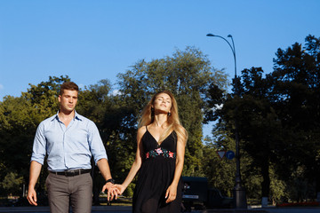 happy couple, man and woman, over black background. hold hands, go and smile