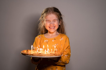 girl holding pizza candles, laughing, eyes closed 