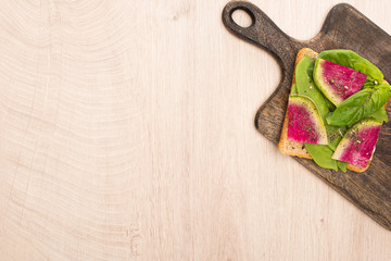 top view of vegetarian radish sandwich on wooden cutting board