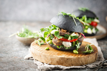 Veggie mushroom, green salad and vegetable black burgers. on gray stone background Copyspace.