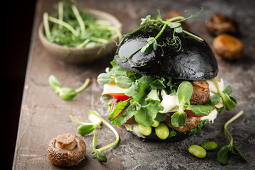 Veggie mushroom, green salad and vegetable black burgers. on gray stone background Copyspace.