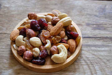 Mix of nuts and dried fruits at weathered wooden background