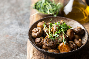 Baked champignons mushrooms with butter and roasted garlic in a bowl. Healthy food concept.