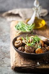 Baked champignons mushrooms with butter and roasted garlic in a bowl. Healthy food concept.