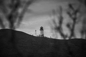 Lighthouse, standing on the hill. The picture was taken in black and white. The lighthouse was...