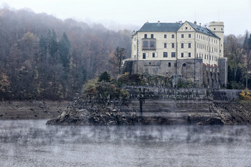Fototapeta na wymiar Orlik chateau on the tall rock under the loose dam