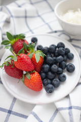 Beautiful healthy breakfast plate with strawberries and blueberries on a checkered napkin 