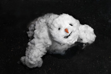 Snowman is melting . Thaw, warm winter, early spring, global warming, climate change background.