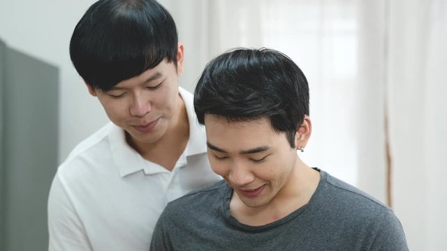 Couple gay preparing some food in kitchen together and give to the other with sometime they hug and smile. 