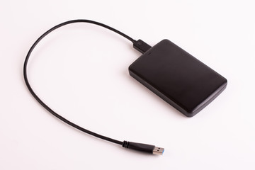 Obraz premium Hard drive close up. Portable hard drive with usb wire on a white background.