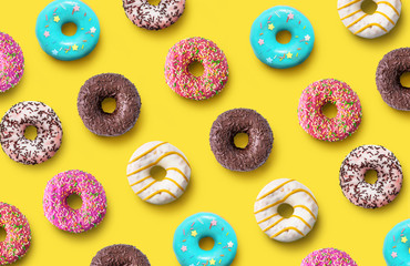 Delicious donuts pattern on a yellow background. Top view. Flat lay. Summer concept - obrazy, fototapety, plakaty