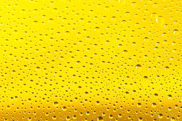 Water drops background. Rain texture on Yellow window glass. Wet pattern.