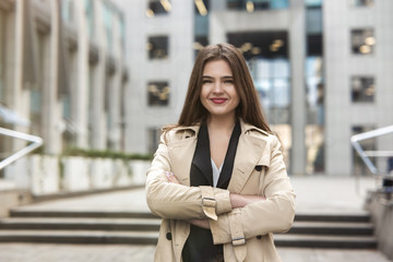 stylish young businesswoman wearing smart outfit stands in the middle of the street looking gorgeous, style and beauty concept
