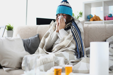 Portrait of sad ill woman blowing nose in paper napkin. Diseased person on sick leave. Female taking medication. Seasonal sickness and treatment concept - obrazy, fototapety, plakaty