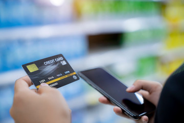 Hands using credit card for payment on mobile phone online