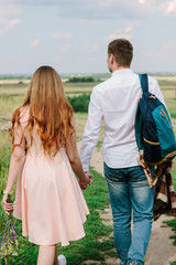 Back view of young couple walking on the nature