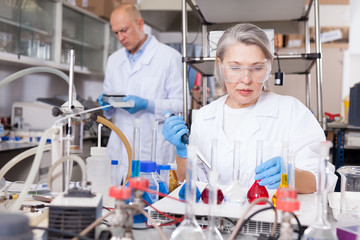 Female biochemists mixing chemicals