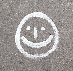 Smiling face is drawn on the asphalt.