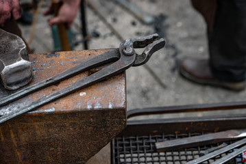 Metal tongs over the anvil - blacksmith equipment