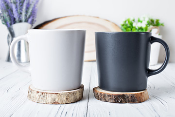 White and black mugs on a background of flowers . Mock up. Template Space for Creative Artwork Lettering Text Product Promotion Branding. Elegant style.