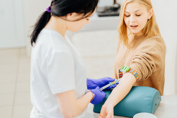 nurse with syringe is taking blood for test at the doctor office