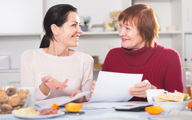 Fototapeta premium Happy women with documents sitting at table