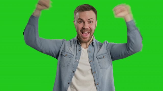 Happy man rejoicing success at chroma key. Bearded man celebrating win. Close-up in 4K, UHD