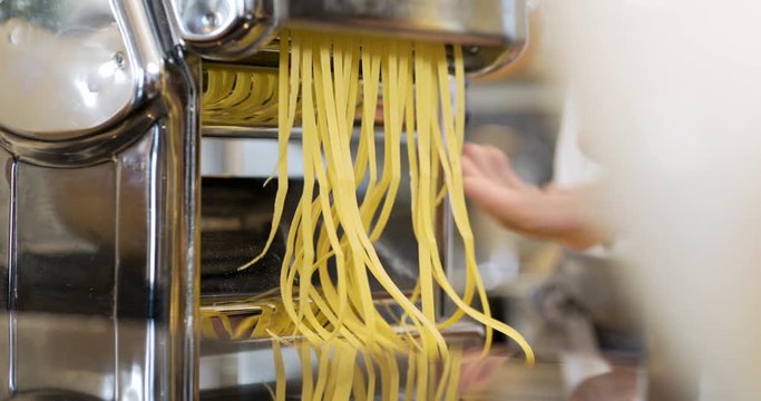cook prepares pasta in kitchen