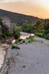 Fototapeta na wymiar River in the hills of an old idyllic french village during sunset.