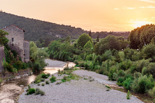 River in the hills of an old idyllic french village during sunset.