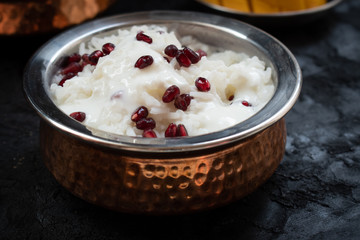 Indian yogurt rice pomegranate served in traditional bowl
