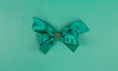 green silk gift bow ribbon isolated on green background