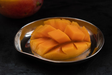 Half cut mango on mango shaped  stainless steel platter