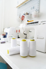 Sewing: several large skeins of white thread for sewing machines on the tailor's desk.