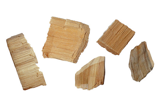 Set of wood chips on a white background. Top view of a group of wood chips on a white background. Oak wood chips. Parts of pine or oak wood chips on a white background, top view.