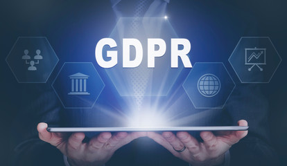 Businessman holding a computer tablet display projecting a GDPR concept.