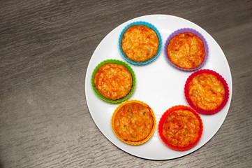 fish muffins. rainbow colored tartlets. on plate. on black wooden background
