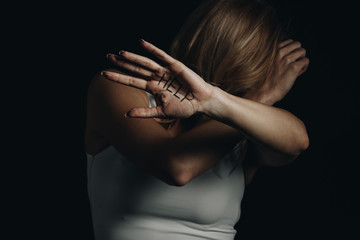 Victim hiding and showing palm with help lettering isolated on black