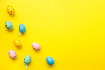 Fototapeta na wymiar Easter colored eggs on yellow background. Happy Easter greeting card minimal concept. Top view, flat lay