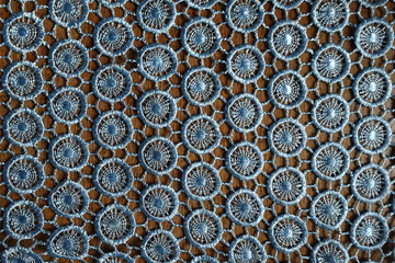 Light blue crochet lacy fabric on wood from above