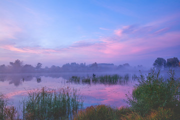 Naklejka na ściany i meble Magic sunrise over the lake. Misty early morning, rural landscape, wilderness, mystical feeling. Serenity lake in magical light
