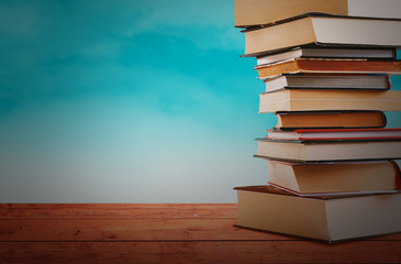 Pile of Books on Wooden Table with Blue Background