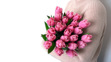 Mother's Day and Women's day greeting card concept. A bouquet of fresh tulips in their hands. Gentle hugs mothers and daughters.